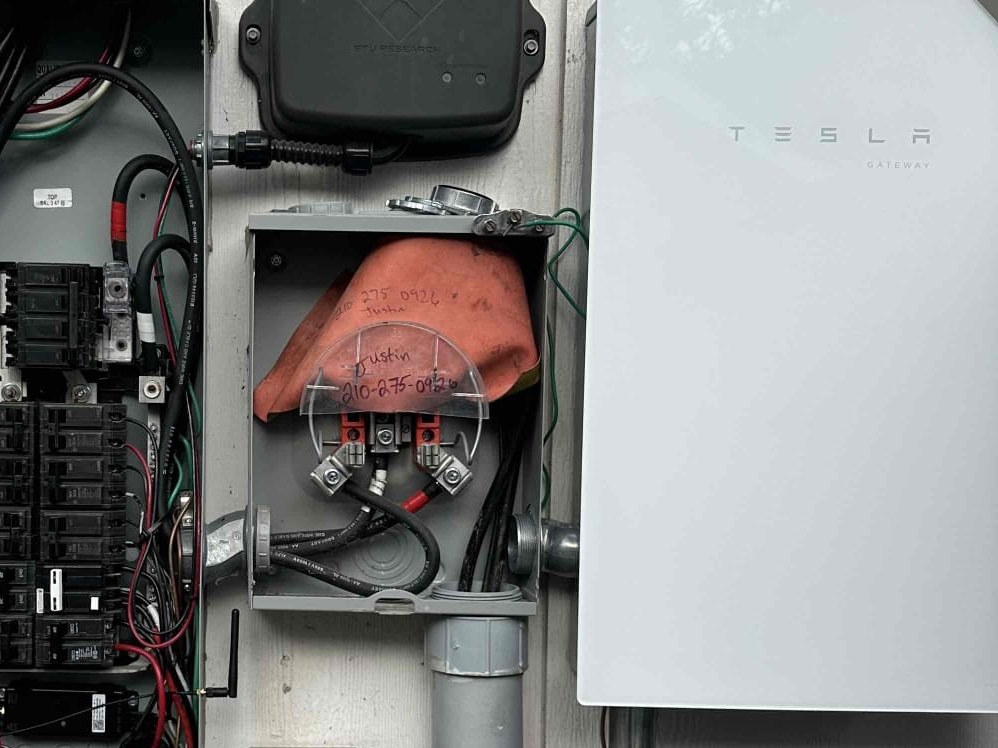 Tesla Powerwall mounted on the exterior wall of a San Antonio home beside its disconnect