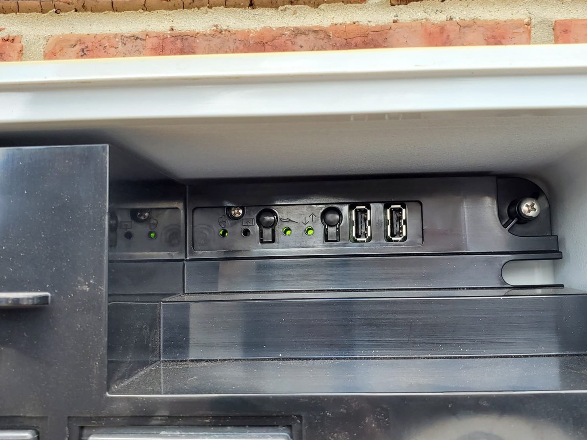 Microinverter and connectors on the mounting rail beneath a solar panel