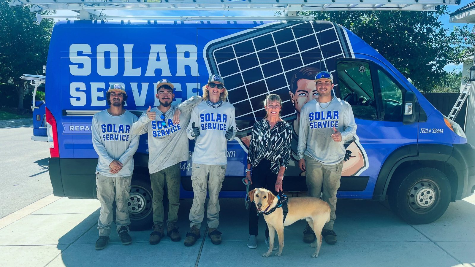 The Solar Service crew with a homeowner and her dog